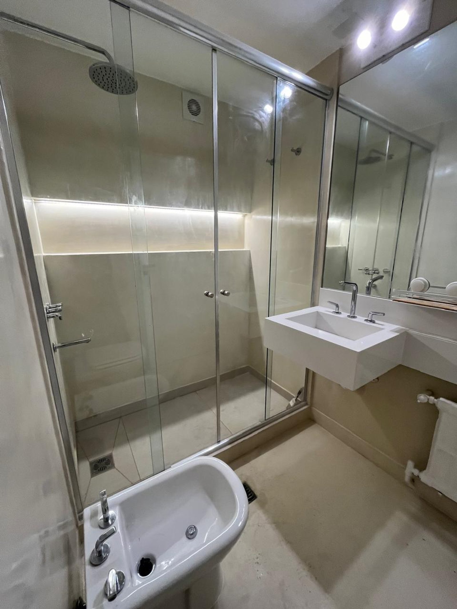 Banheiro moderno com box de vidro, bidê e lavatório de parede — projeto Alvear, por Estudio NET Arquitectura, em Marcelo Torcuato de Alvear